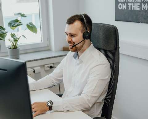 a man wearing a headset sitting in front of a computer