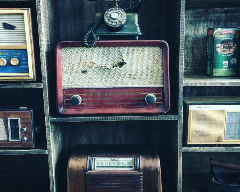 black rotary telephone on red transistor radio