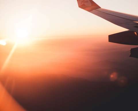 a view of the wing of an airplane as the sun sets