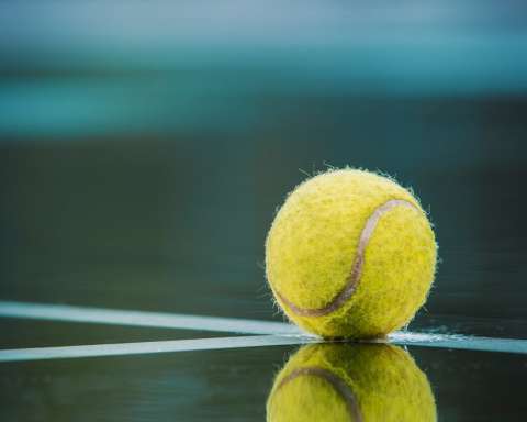 a tennis ball sitting on top of a tennis court