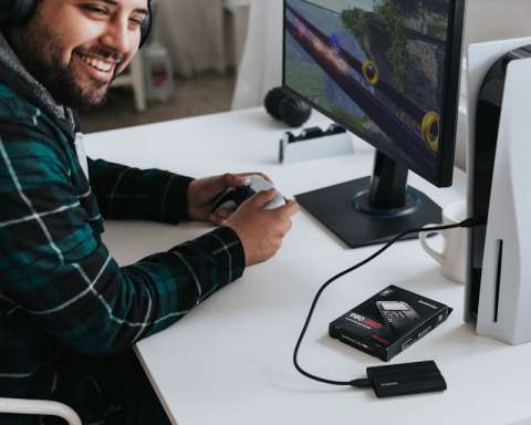 a man wearing headphones and sitting at a desk with a computer